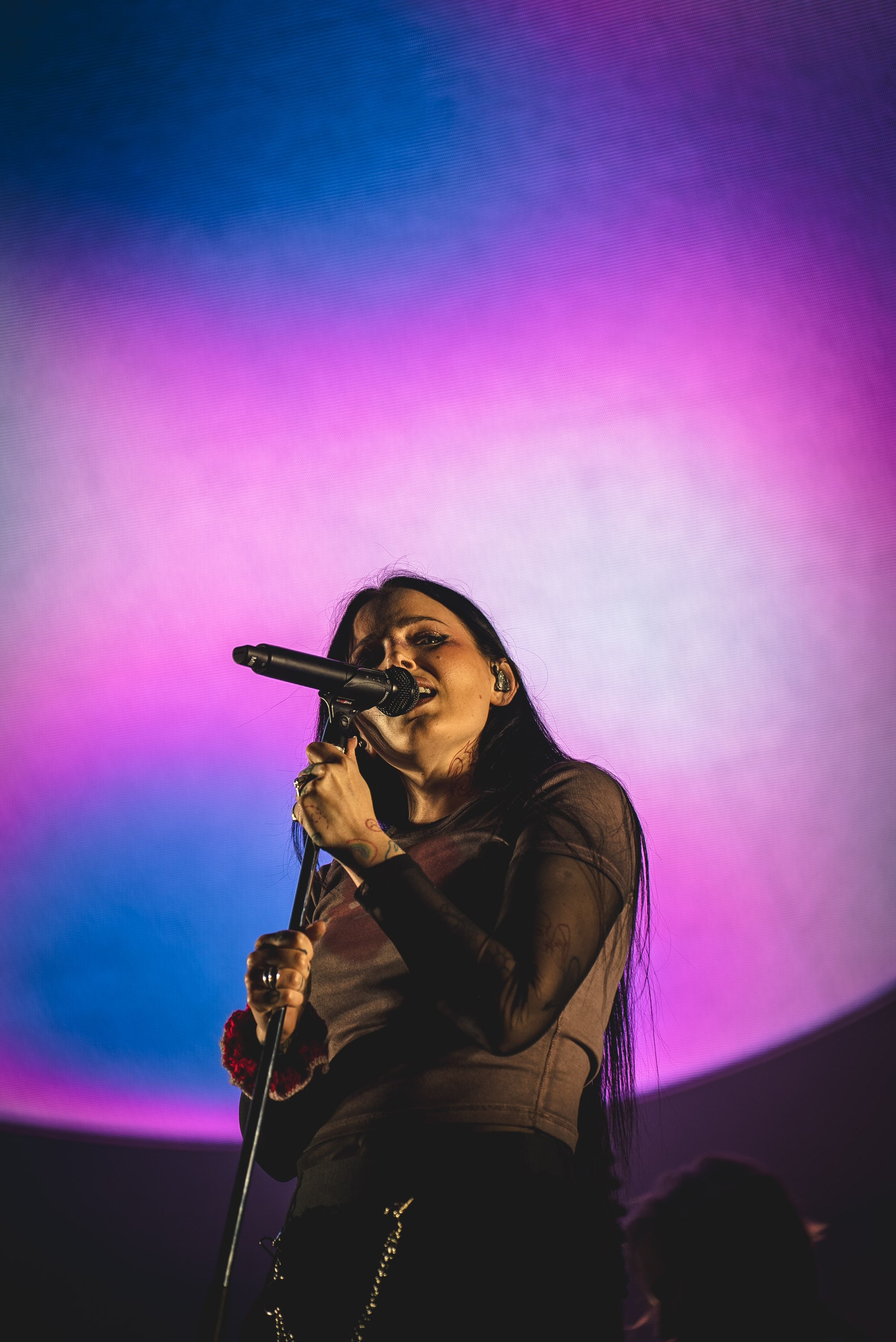 Miriam Bryant singing against a pink and blue backdrop